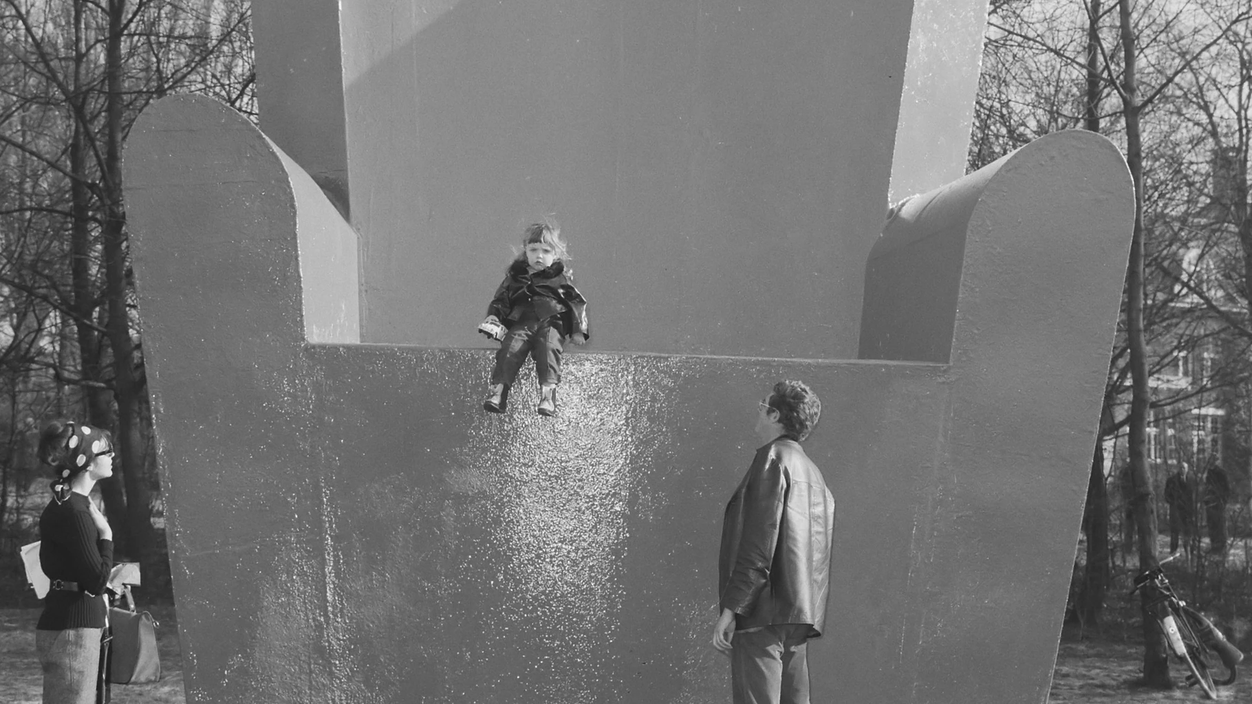 Wim T. Schippers's monumental armchair sculpture in the Vondelpark in 1965, a child seated on the armrest as visitors look up