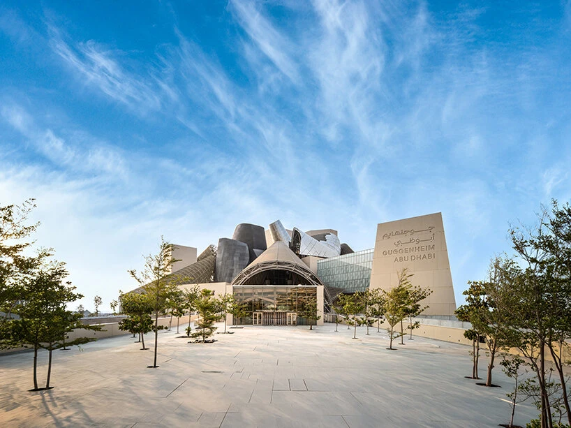The finished entrance plaza of Guggenheim Abu Dhabi with young trees and stone paving