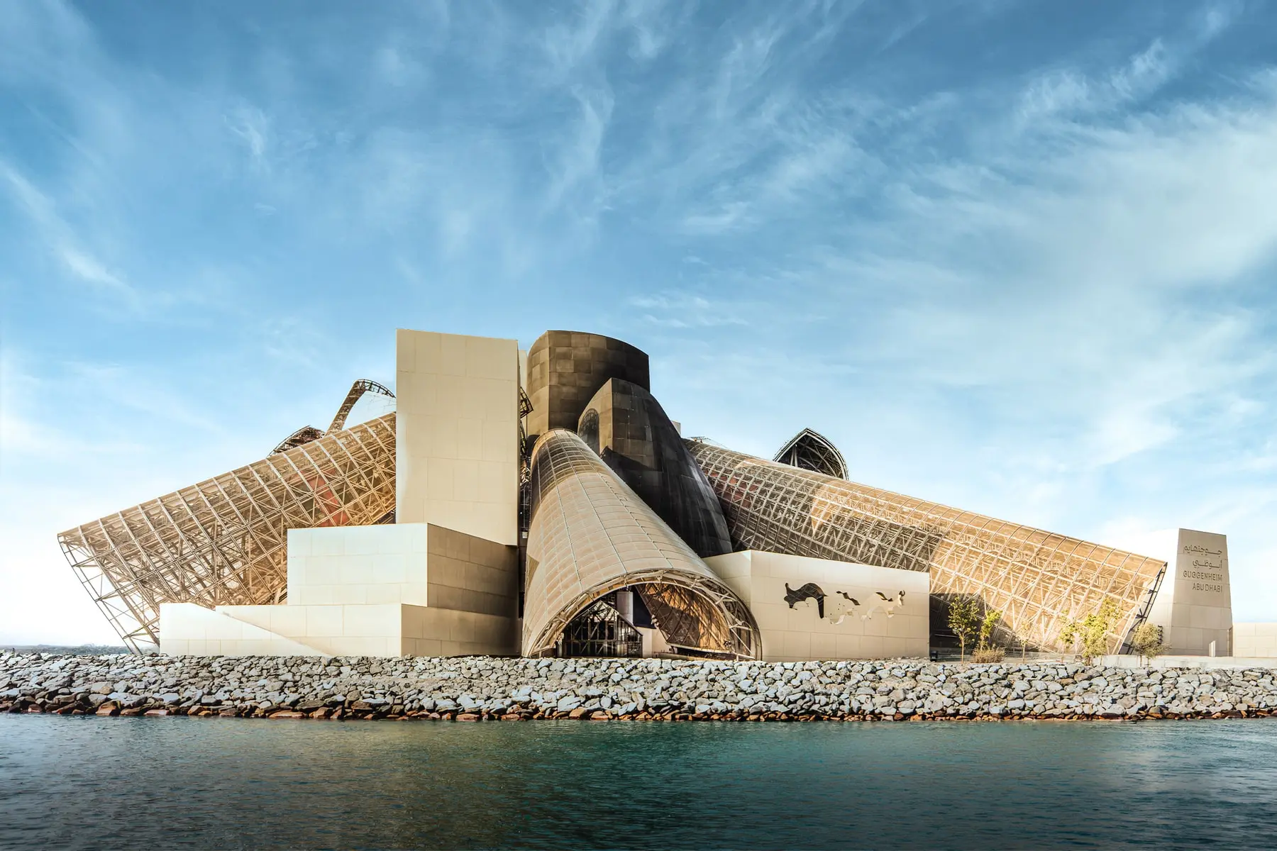Exterior view of Guggenheim Abu Dhabi showing Frank Gehry's clustered steel and glass cone structures on Saadiyat Island