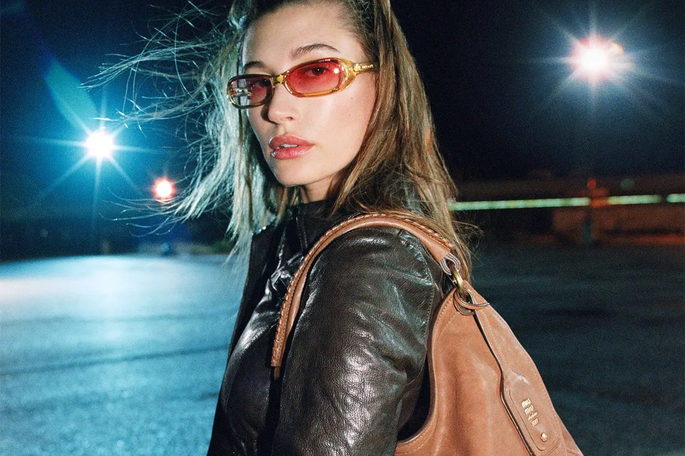 Hailey Bieber photographed for Miu Miu Fall Winter 2026 campaign in nocturnal industrial setting wearing oversized shearling outerwear