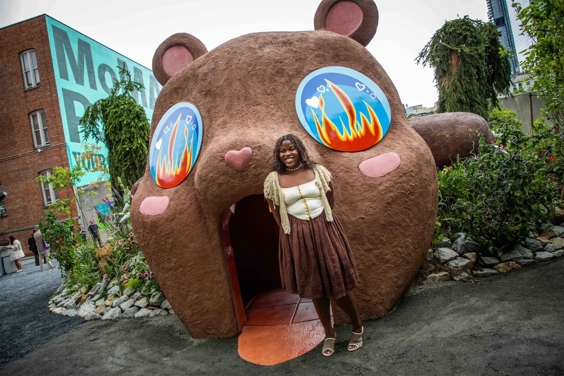 Precious Okoyomon's 25-foot teddy bear slide sculpture installed in the MoMA PS1 courtyard garden