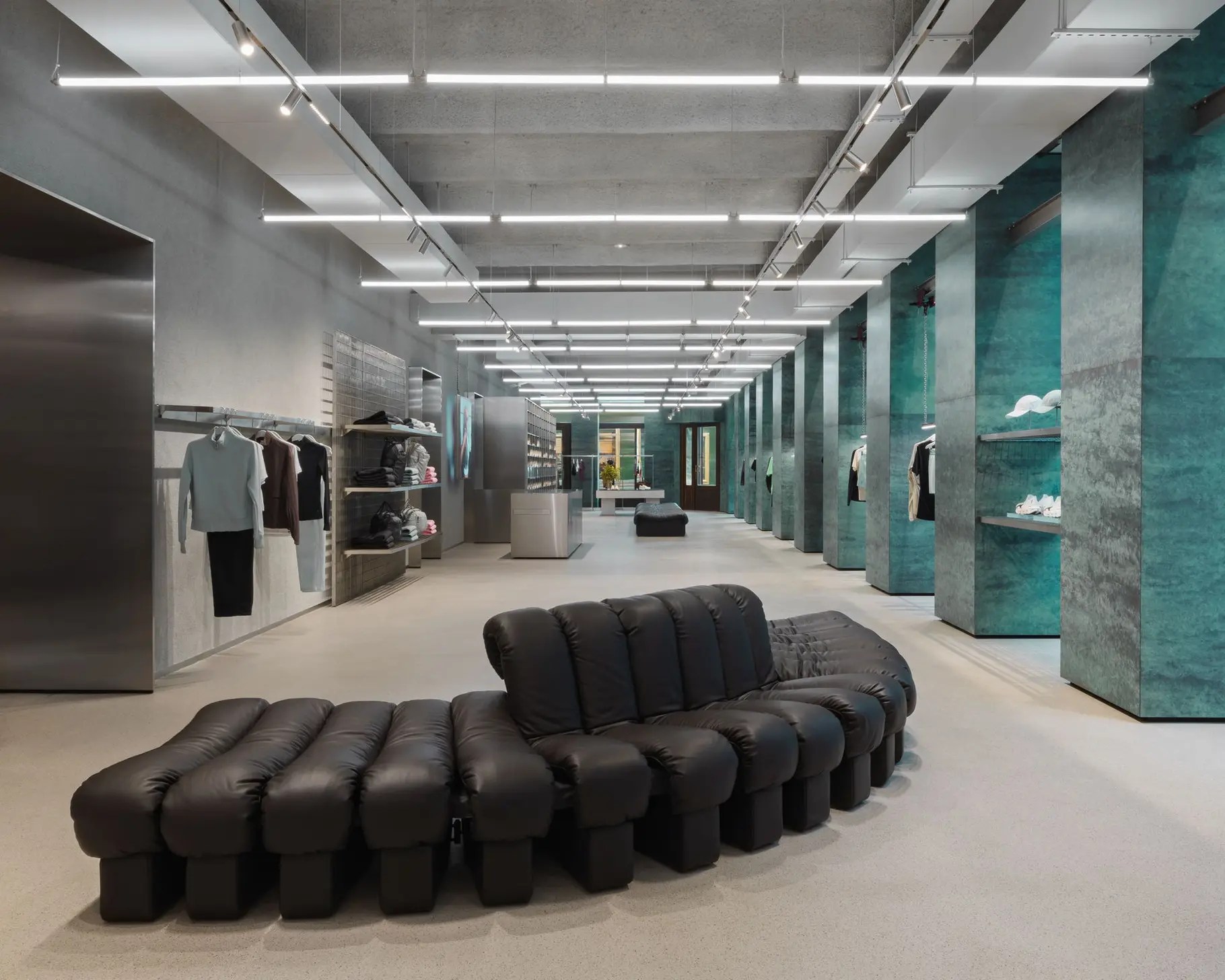 Interior of an On direct-to-consumer store in Vienna with footwear displayed on wall shelving.